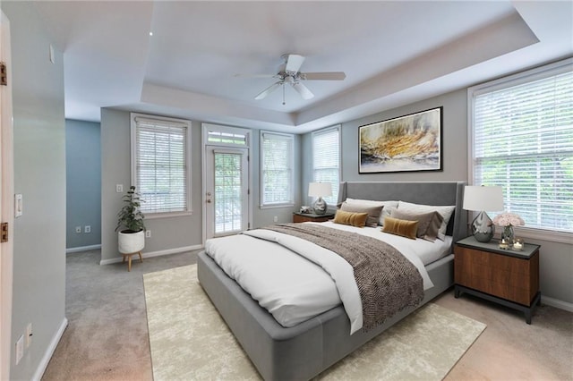 bedroom featuring a raised ceiling, access to exterior, and ceiling fan