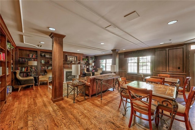 dining space featuring ornate columns and light wood-type flooring