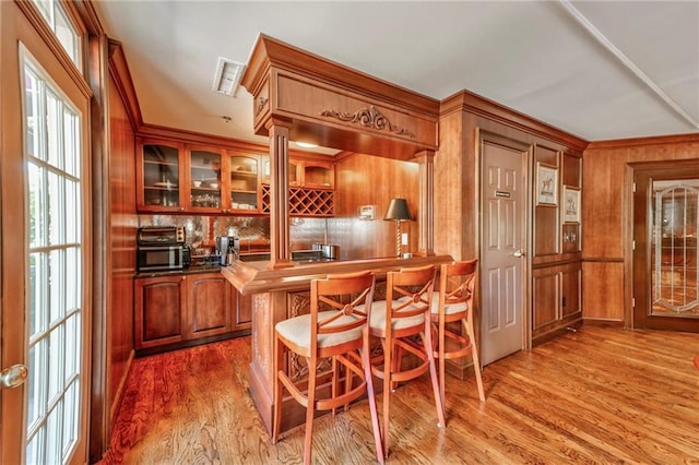 bar with hardwood / wood-style floors and wood walls