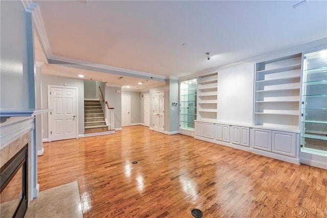 unfurnished living room with ornamental molding and light hardwood / wood-style flooring