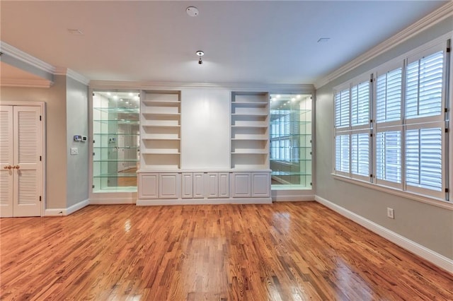 unfurnished living room featuring ornamental molding and light hardwood / wood-style floors