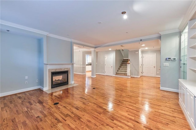 unfurnished living room with crown molding, a multi sided fireplace, and light wood-type flooring