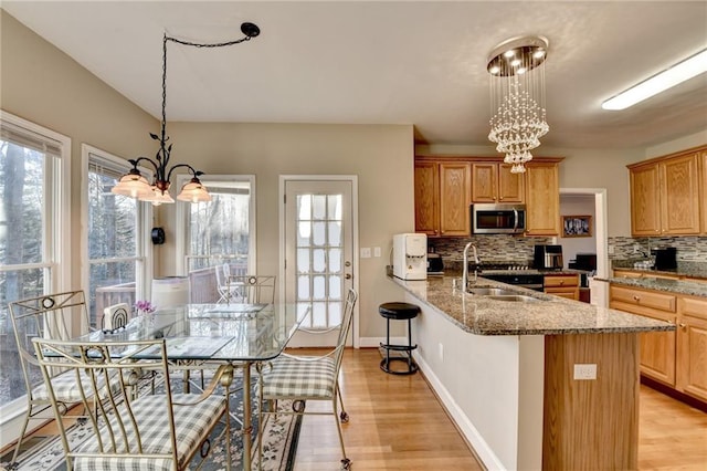 kitchen with an inviting chandelier, decorative light fixtures, sink, and tasteful backsplash