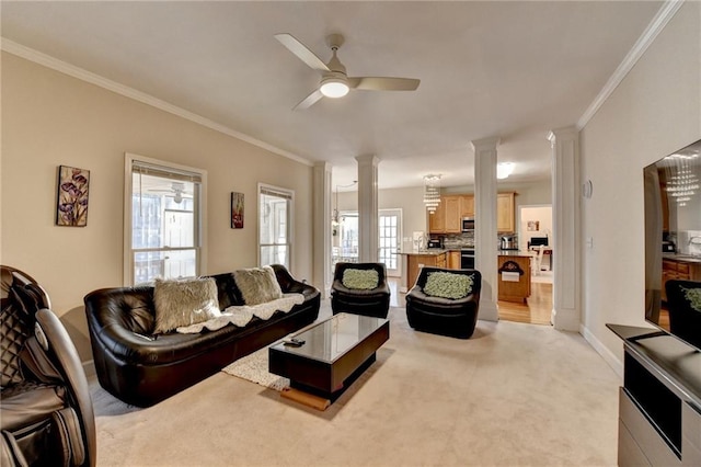 living room featuring light carpet, crown molding, decorative columns, and ceiling fan