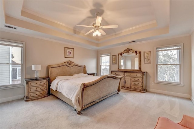 carpeted bedroom with a raised ceiling, ornamental molding, and ceiling fan