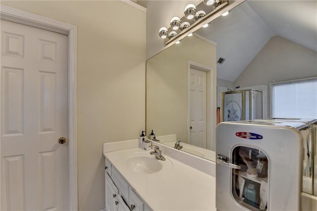 bathroom featuring vanity, vaulted ceiling, and walk in shower