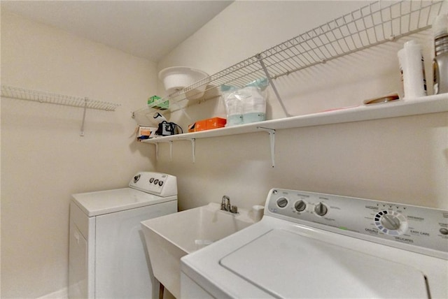 clothes washing area with sink and washer and clothes dryer