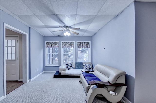 interior space featuring ceiling fan, carpet flooring, and a drop ceiling