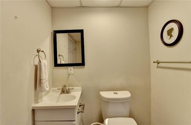 bathroom featuring a paneled ceiling, vanity, and toilet