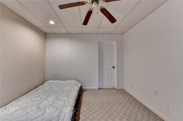 bedroom with a paneled ceiling, ceiling fan, and carpet