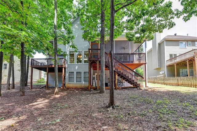 rear view of property with a sunroom and a deck