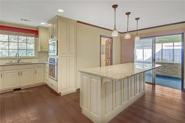 kitchen featuring light stone counters, dark wood-type flooring, a sink, and oven