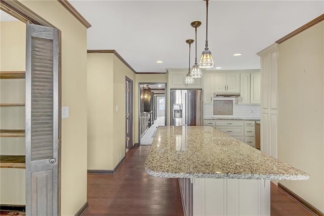 kitchen featuring under cabinet range hood, dark wood-style flooring, stainless steel refrigerator with ice dispenser, backsplash, and crown molding