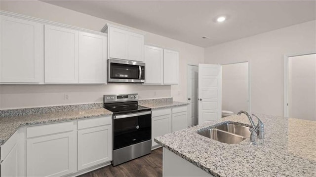 364 Sound Cir, Stockbridge, GA 30281 - kitchen featuring appliances with stainless steel finishes, white cabinetry, dark wood-style floors, light stone counters, and recessed lighting
