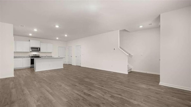 364 Sound Cir, Stockbridge, GA 30281 - unfurnished living room with recessed lighting, dark wood-style floors, and stairs