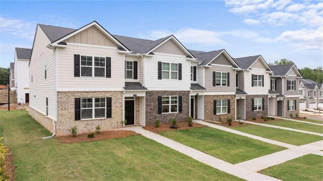 364 Sound Cir, Stockbridge, GA 30281 - view of front of property featuring brick siding, board and batten siding, a front lawn, and a residential view