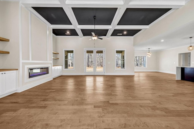 125 Drummond Pl, Covington, GA 30014 - unfurnished living room featuring ceiling fan, a glass covered fireplace, light wood-style flooring, beam ceiling, and coffered ceiling