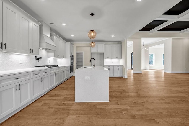 125 Drummond Pl, Covington, GA 30014 - kitchen with stainless steel gas cooktop, custom range hood, recessed lighting, white cabinets, and tasteful backsplash