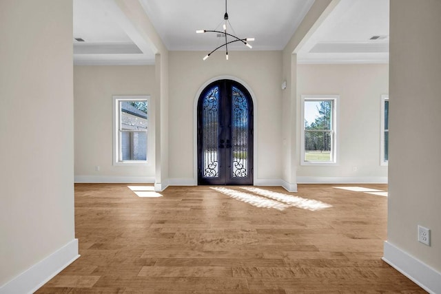 125 Drummond Pl, Covington, GA 30014 - foyer entrance featuring french doors, a chandelier, crown molding, baseboards, and light wood finished floors