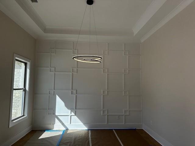 unfurnished room featuring baseboards, dark wood-style flooring, a raised ceiling, and a healthy amount of sunlight