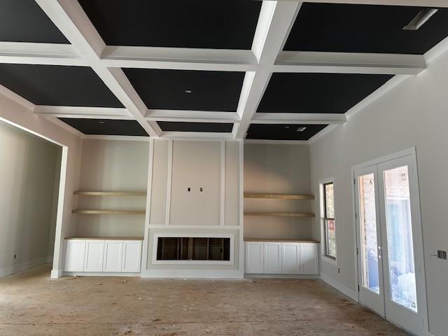 unfurnished living room featuring french doors, coffered ceiling, and beam ceiling