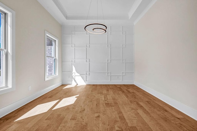 125 Drummond Pl, Covington, GA 30014 - unfurnished dining area featuring baseboards, light wood-style floors, a chandelier, crown molding, and a tray ceiling