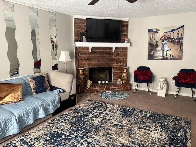 231 Forest Pl, Lawrenceville, GA 30046 - carpeted living room featuring ceiling fan, a brick fireplace, and a textured ceiling