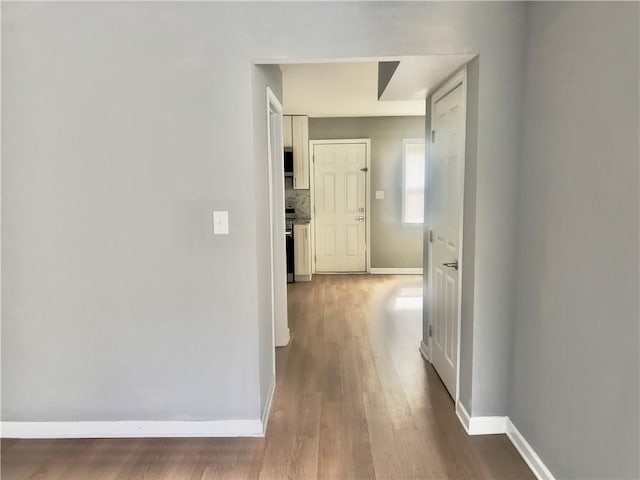 hallway with hardwood / wood-style flooring