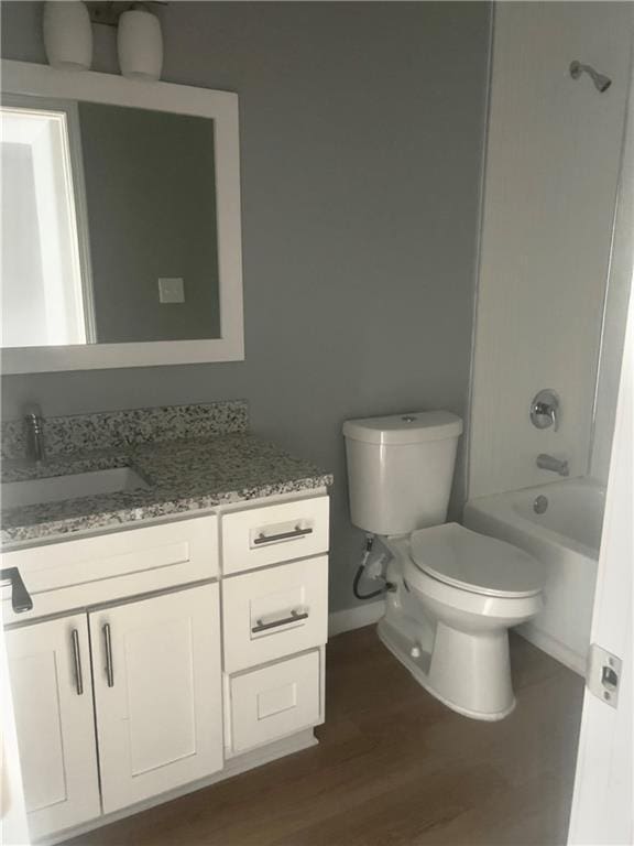 full bathroom with vanity, toilet,  shower combination, and hardwood / wood-style floors