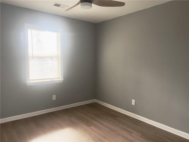 empty room featuring dark wood-type flooring and ceiling fan