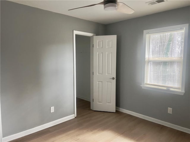 unfurnished bedroom with ceiling fan and light wood-type flooring