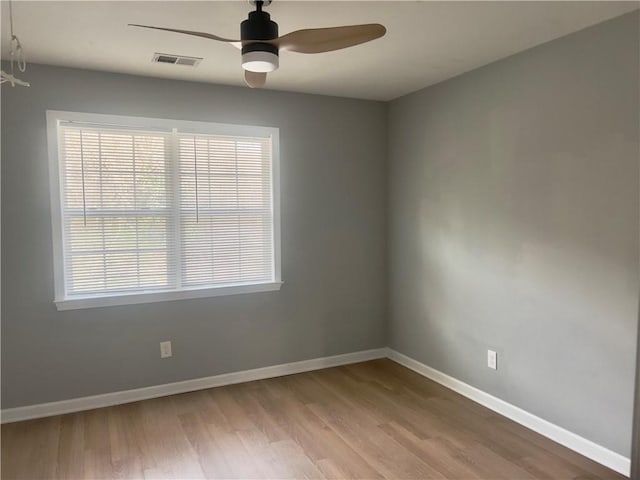 unfurnished room featuring a wealth of natural light, ceiling fan, and light wood-type flooring