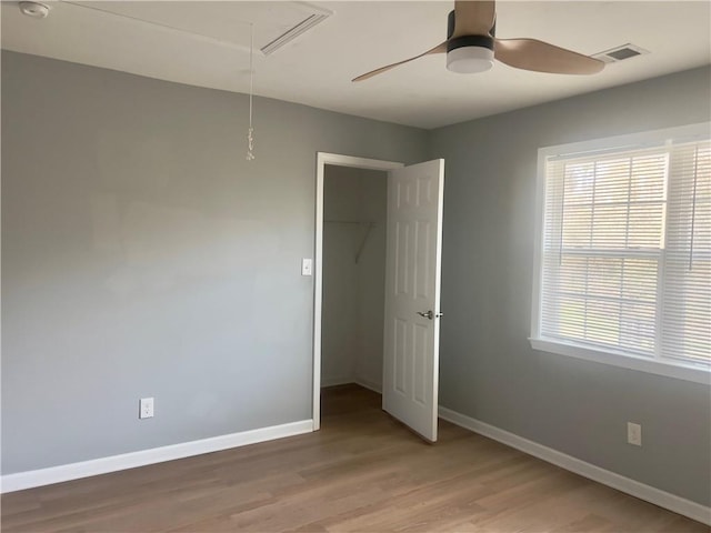 unfurnished bedroom with hardwood / wood-style flooring, ceiling fan, and a closet