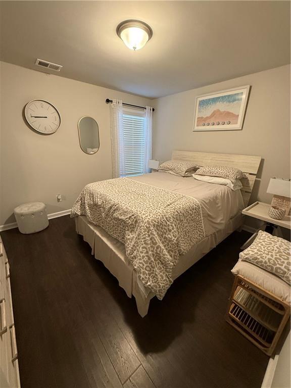 bedroom with dark hardwood / wood-style flooring