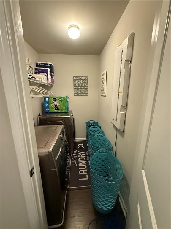 laundry area with dark wood-type flooring and separate washer and dryer