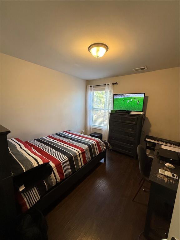 bedroom with dark hardwood / wood-style floors