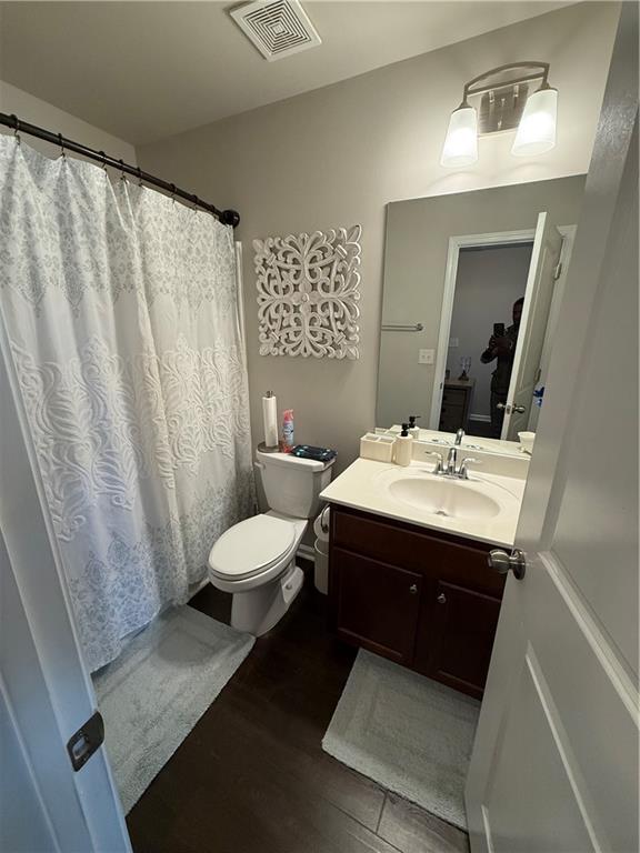 bathroom with toilet, vanity, and hardwood / wood-style flooring