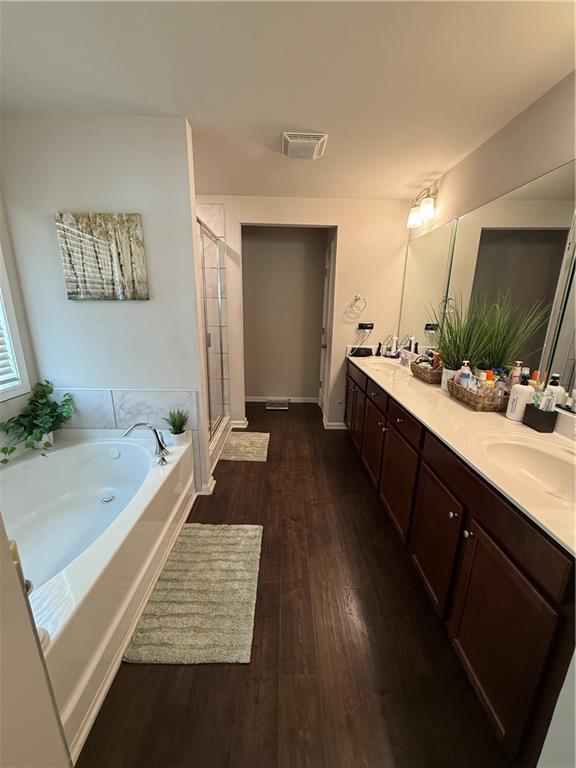 bathroom featuring shower with separate bathtub, vanity, and wood-type flooring