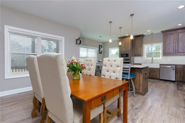 dining room with light wood finished floors, plenty of natural light, recessed lighting, and baseboards