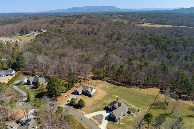 birds eye view of property with a mountain view and a wooded view