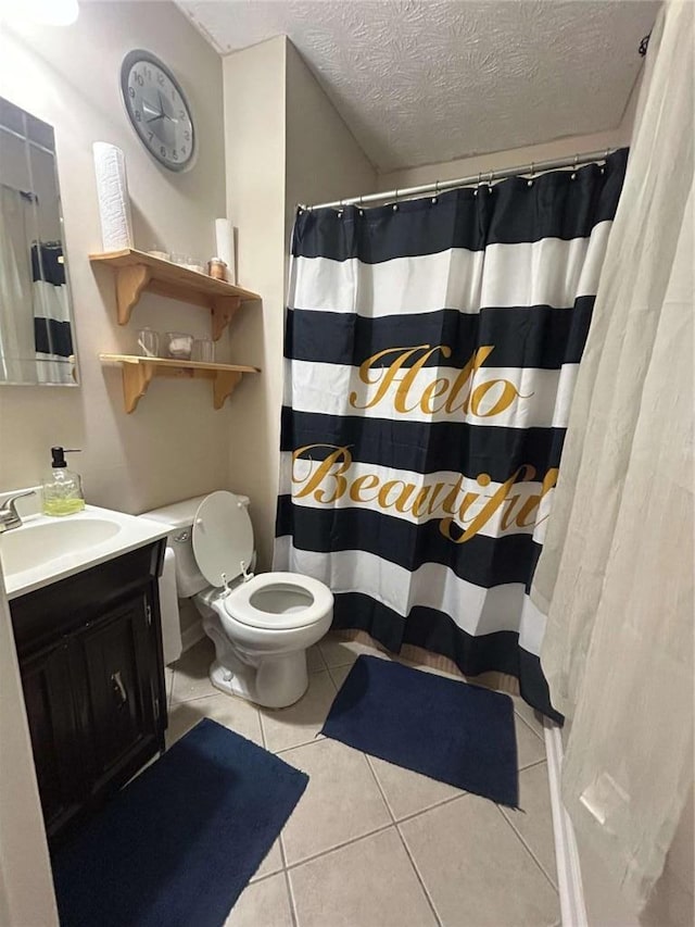 bathroom featuring tile patterned flooring, toilet, vanity, a textured ceiling, and curtained shower