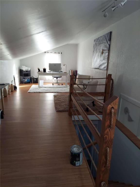 bedroom with wood finished floors, lofted ceiling, and an office area