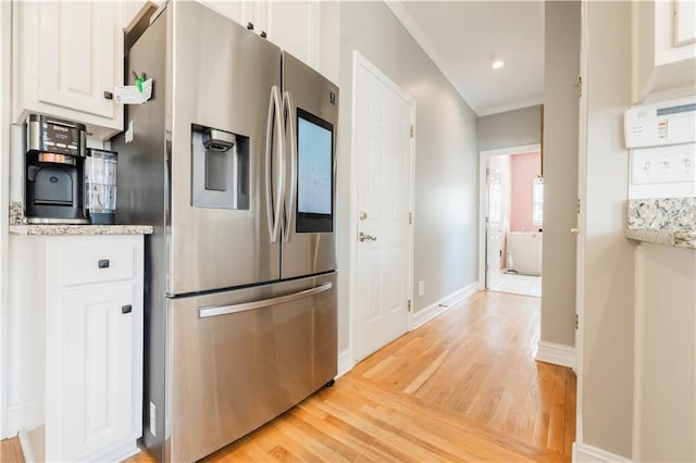 kitchen with white cabinets, light hardwood / wood-style floors, and stainless steel refrigerator with ice dispenser