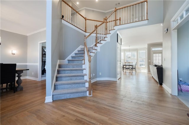 stairs featuring crown molding and wood-type flooring