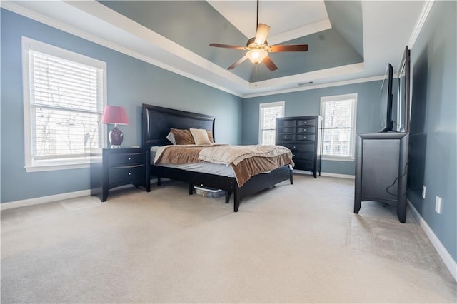 carpeted bedroom with ceiling fan, a tray ceiling, and crown molding