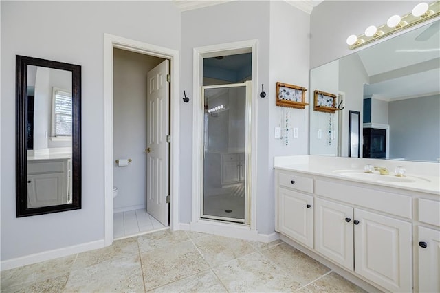 bathroom featuring vanity, a shower with shower door, and toilet