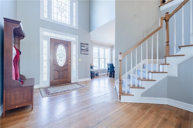 foyer with hardwood / wood-style floors and a towering ceiling