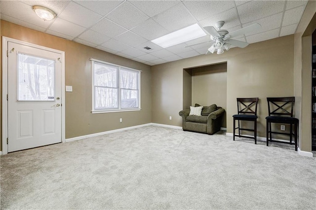 sitting room with ceiling fan, carpet flooring, and a paneled ceiling