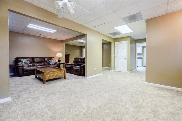 carpeted living room featuring ceiling fan and a paneled ceiling