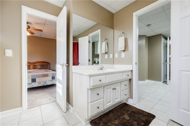 bathroom featuring vanity, ceiling fan, tile patterned floors, and a drop ceiling